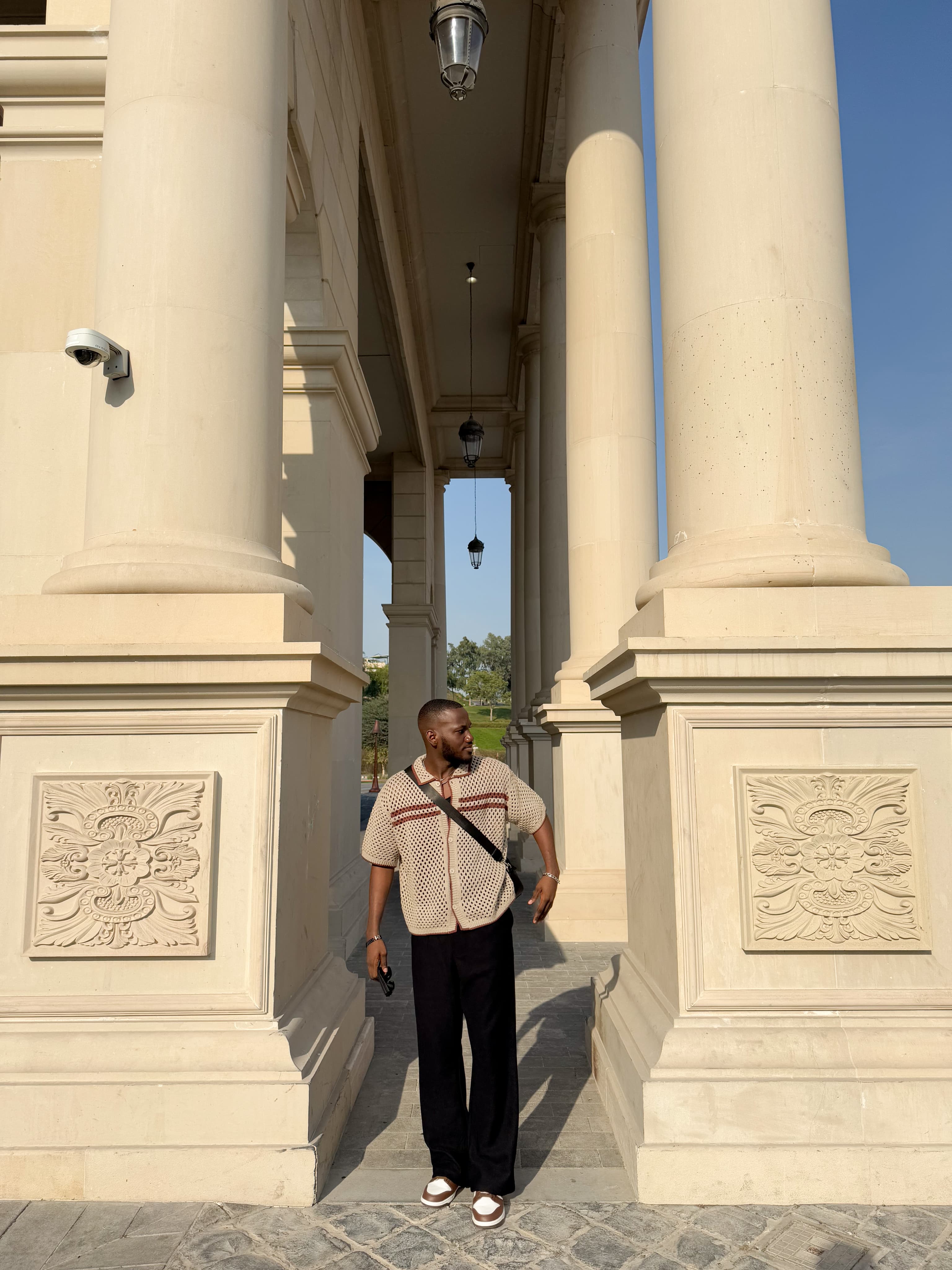 Favour standing between tall architectural columns